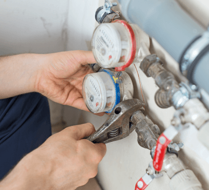 Person's hands adjusting a water meter